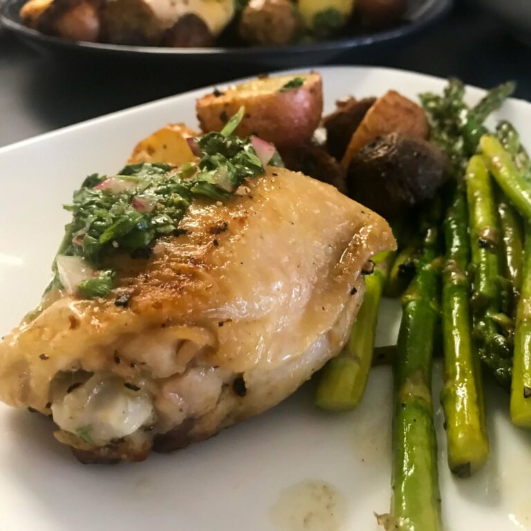 plated chicken thigh, potatoes and asparagus.