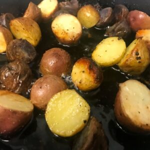 potatoes cooking in oil in a skillet.