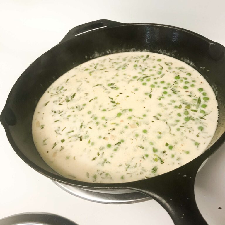 cream tarragon sauce with peas in a skillet.