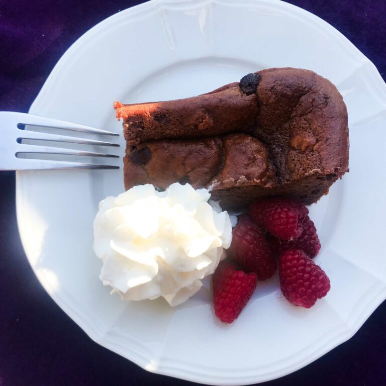 chocolate protein bar on a plate with whipped cream and berries.