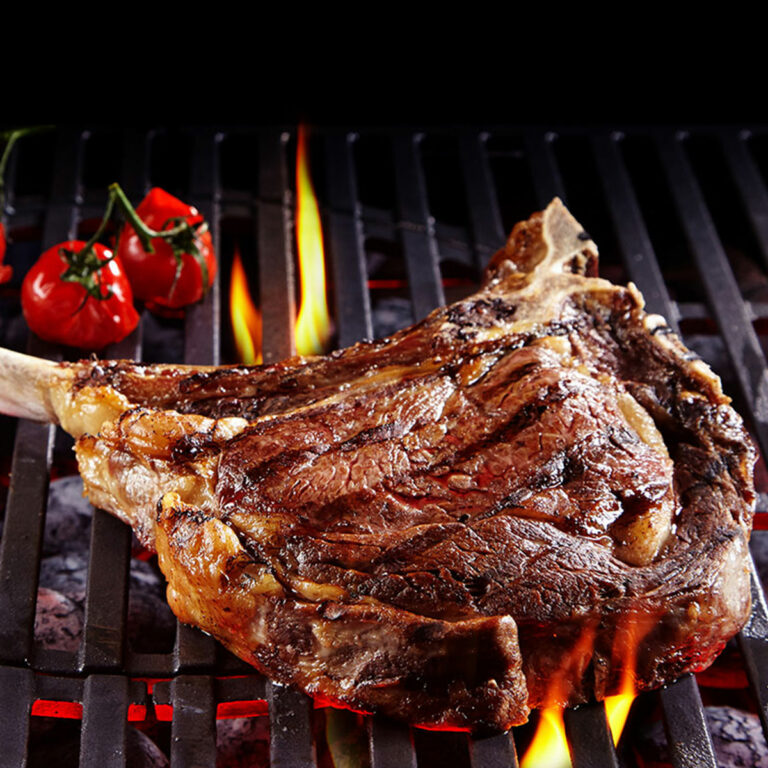 tomahawk steak cooking on a grill.