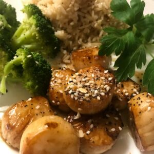 scallops, rice and broccoli on a plate.