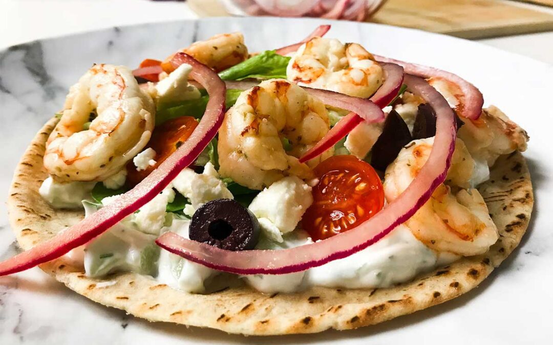 Mediterranean shrimp and tzatziki pita on a plate.