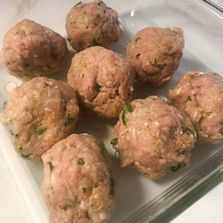 rolled meatballs in a baking dish.