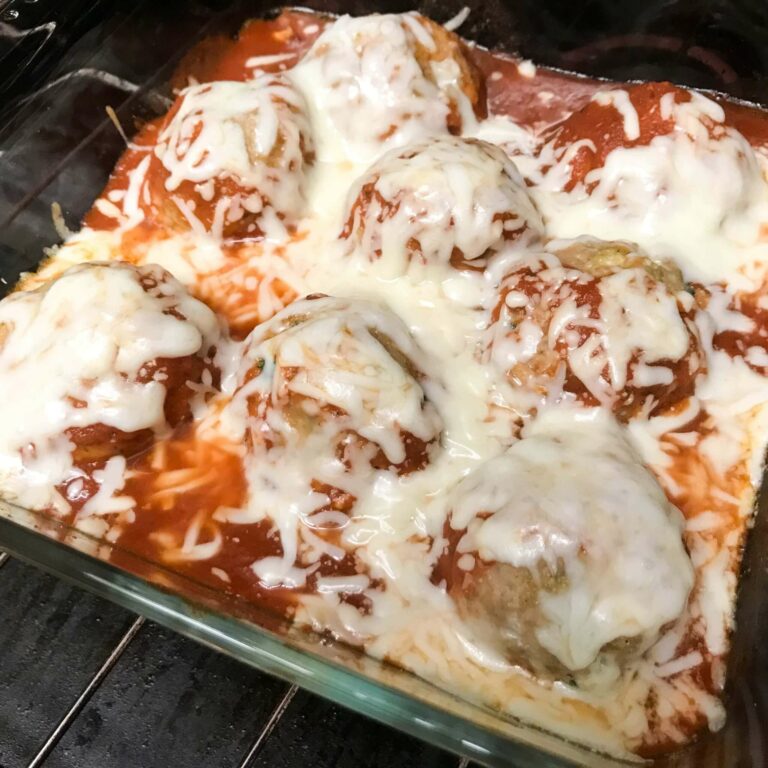 cooked meatballs covered in sauce and cheese.