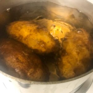 potatoes boiling in a pot of water.