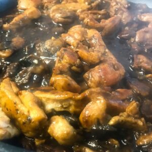 bourbon chicken cooking in skillet.