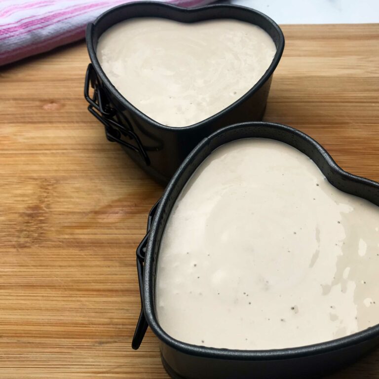 two heart-shaped cheesecake pans filled with batter.