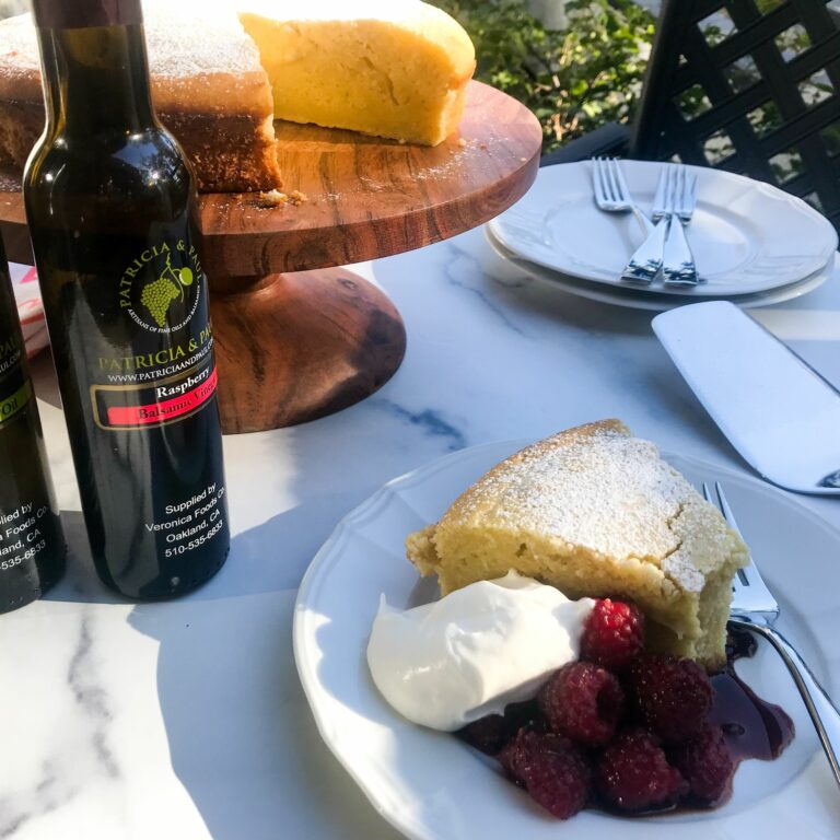 Lemon Olive Oil Cake with Balsamic Raspberries on a plate.