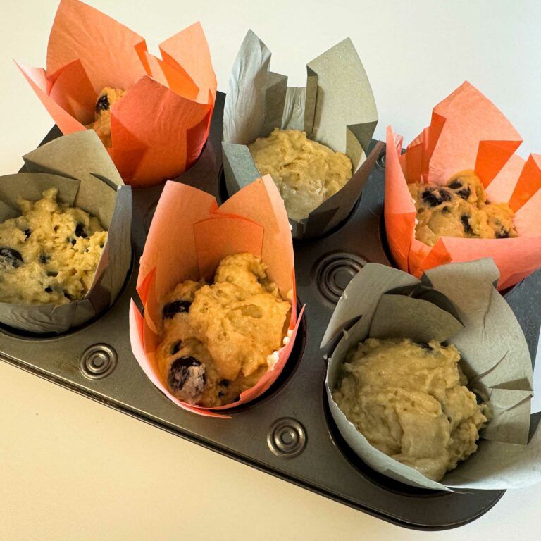raw batter in muffin tin lined with paper liners.