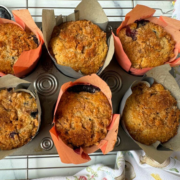 6-cup muffin tin with baked blueberry streusel muffins.