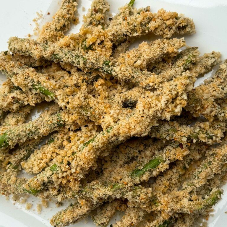 plate of asparagus breaded and ready for frying.