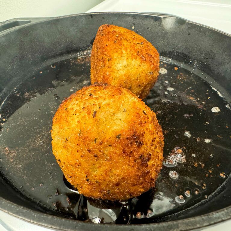 meatballs frying in skillet.