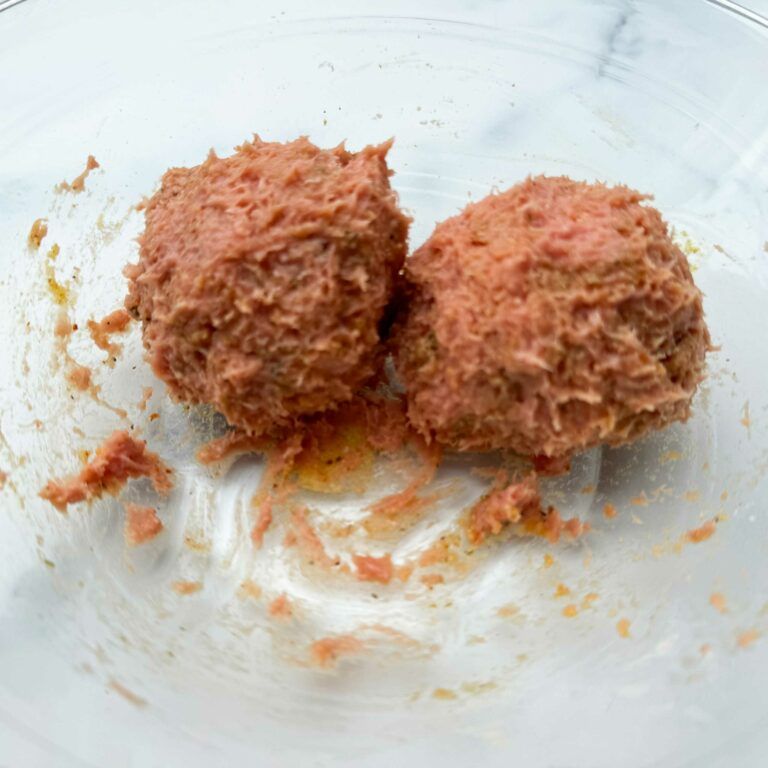 two raw meatballs in a bowl.