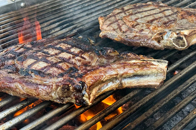 rib eye steaks on grill.