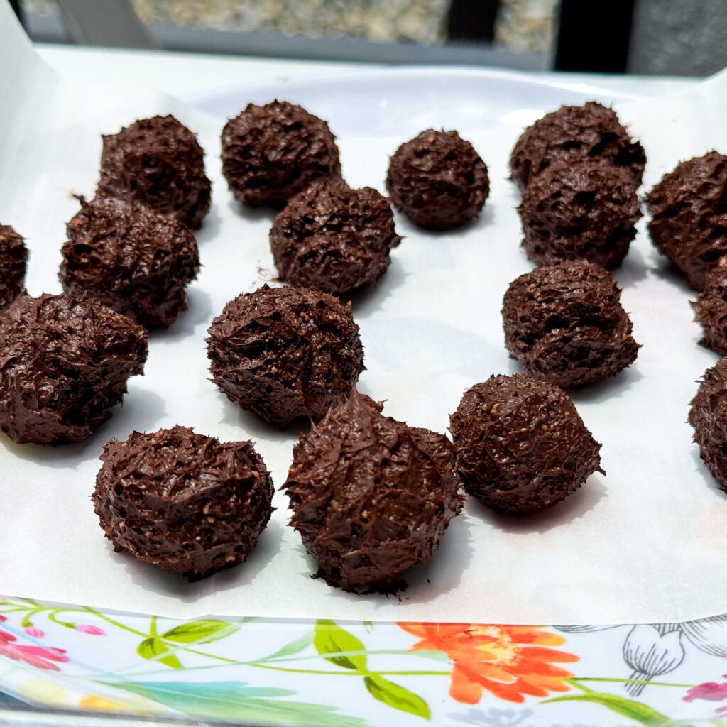 rolled chocolate protein truffles on a plate.