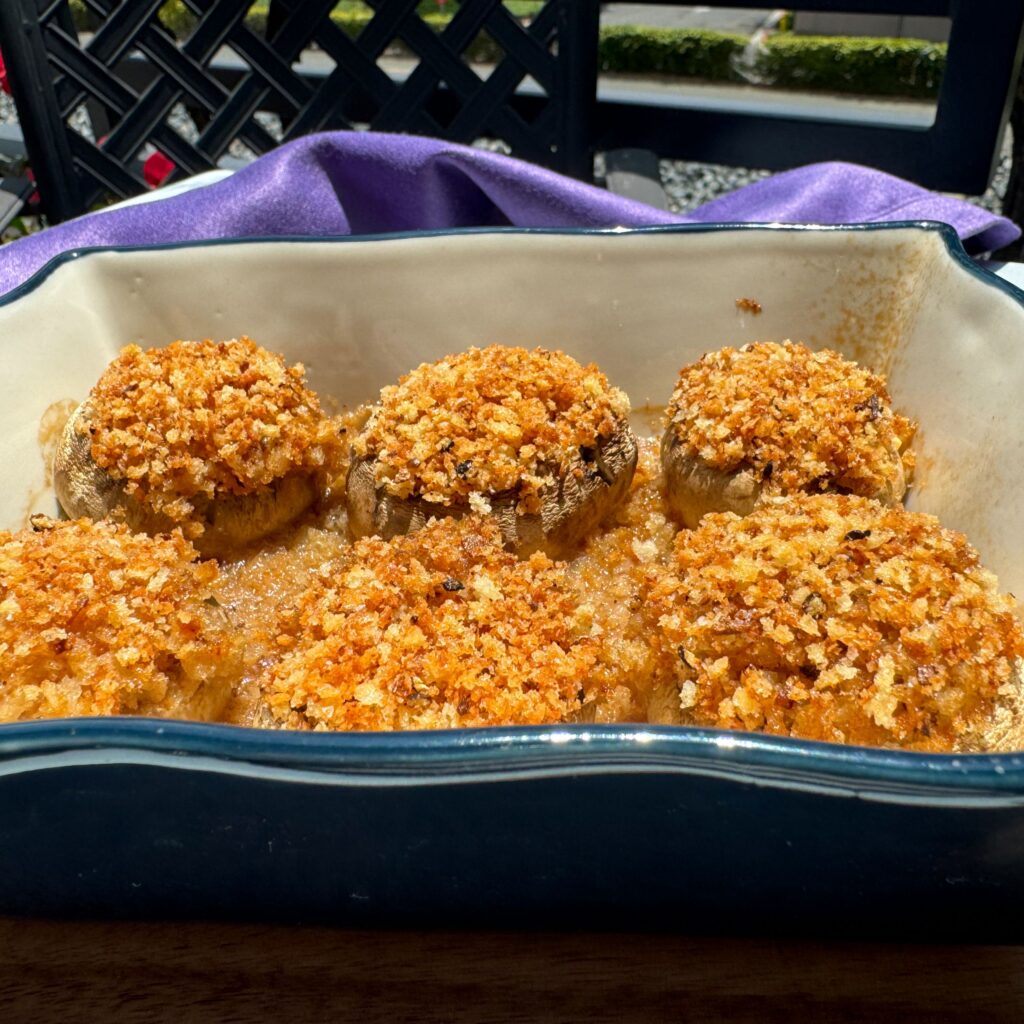 baked boursin cheese stuffed mushrooms in a casserole dish.