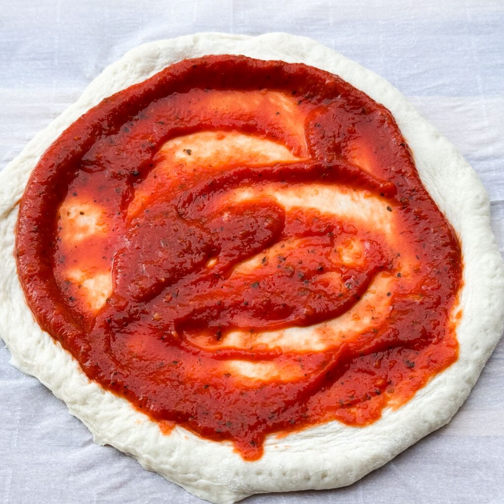 skinny pizza dough with sauce.