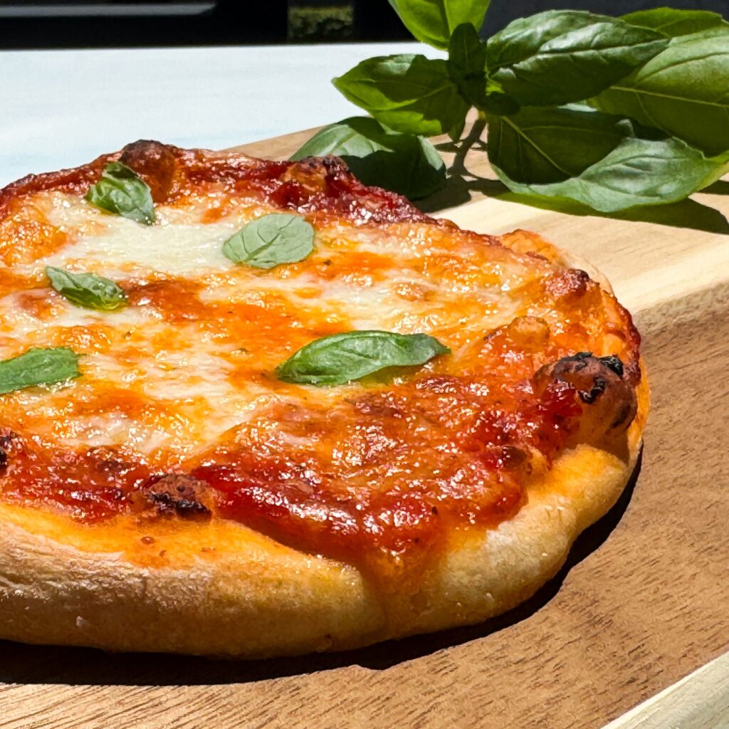 baked pizza pie topped with basil.
