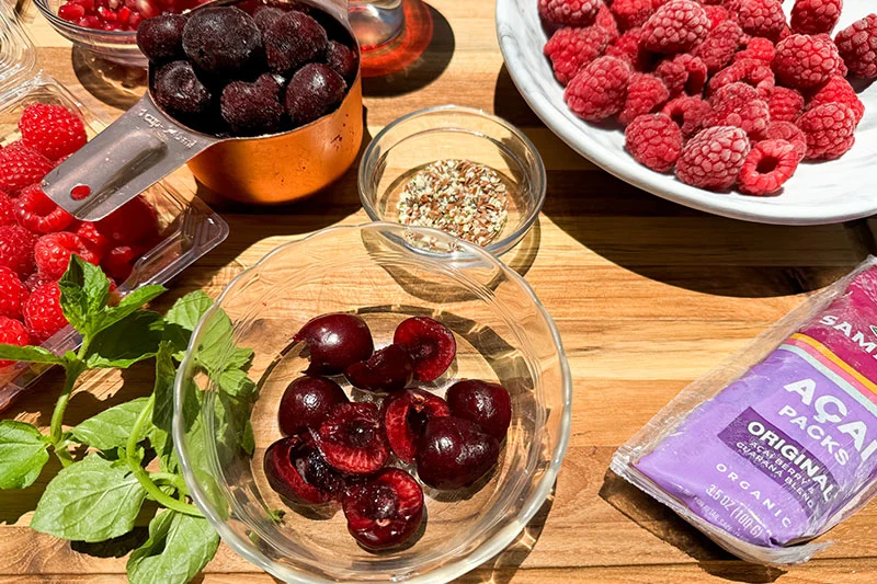 ingredients for cherry, acai, pomegranate and raspberry smoothie bowl.