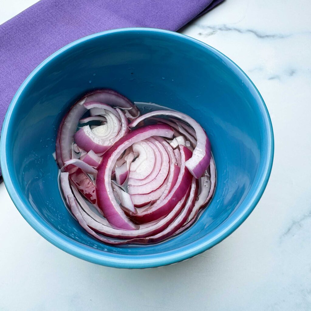 red onions pickling in a bowl.