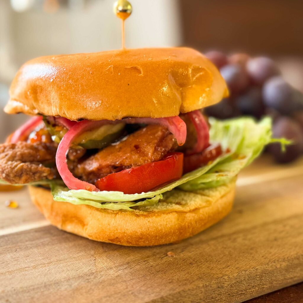 crispy chicken burger with a side of grapes.