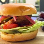 crispy chicken burger with a side of grapes.