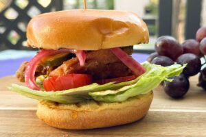 crispy chicken burger with a side of grapes.