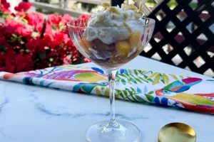 grated frozen peaches and cream in a coup glass.