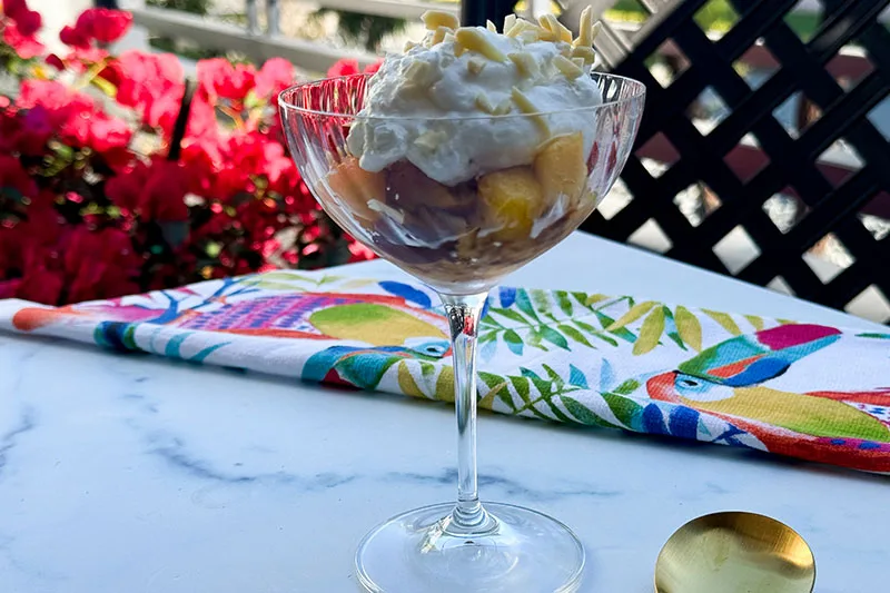 grated frozen peaches and cream in a coup glass.