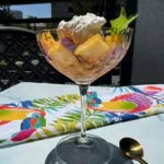 grated frozen peaches and cream in a coup glass.