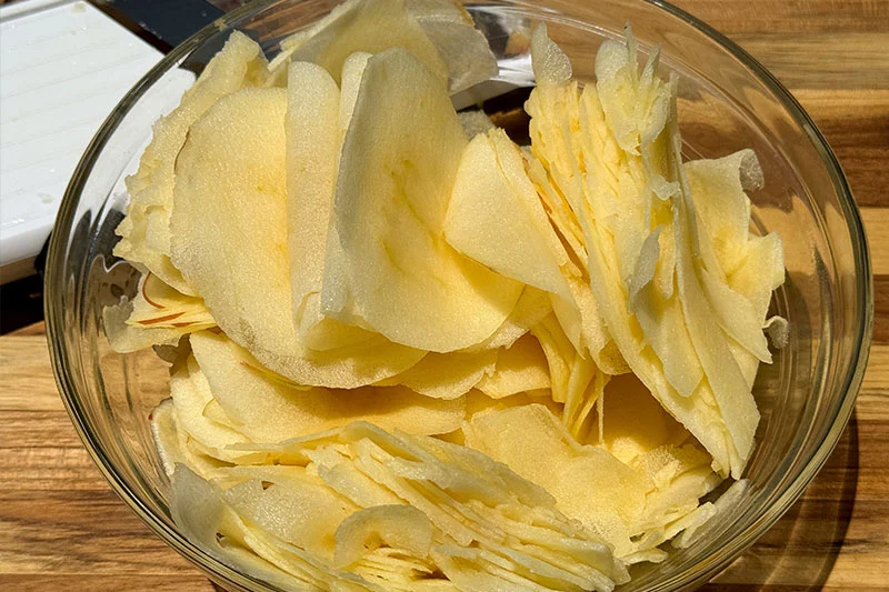 thinly sliced apples in a bowl.