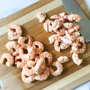 cut shrimp on cutting board.