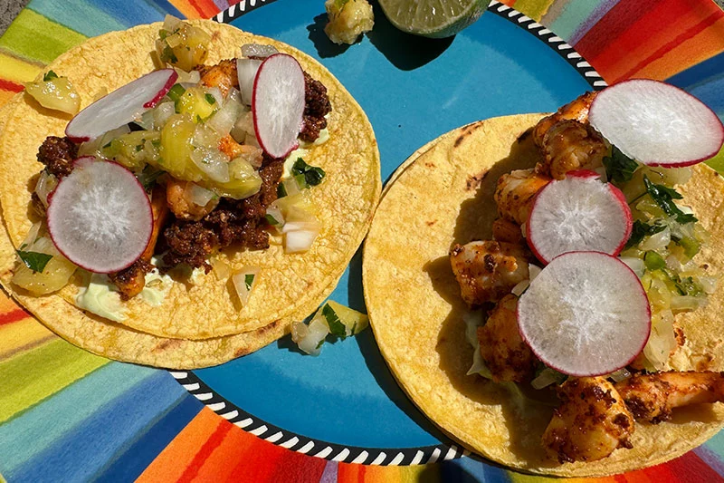 shrimp and chorizo tacos with toppings.