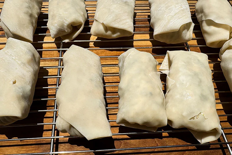 a rack of prepared spring rolls.