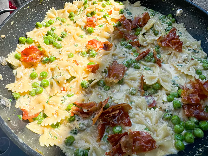 prosciutto added to pasta and peas in sauce.