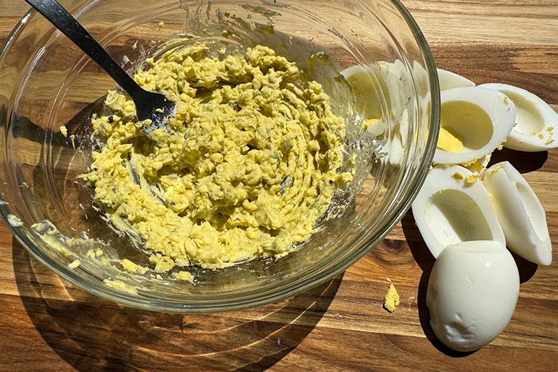 smashed egg yolk and avocado and mayo in a bowl.