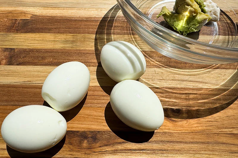 hard boiled eggs on a cutting board.