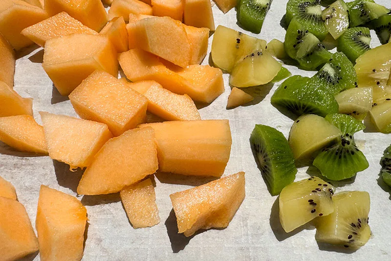 hami melon and kiwi chunks on baking sheet.