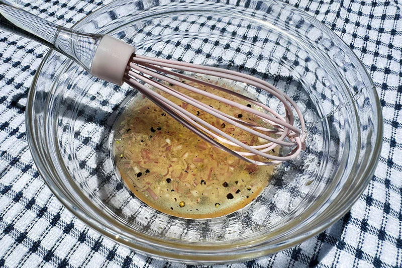 dressing and whisk in a bowl.