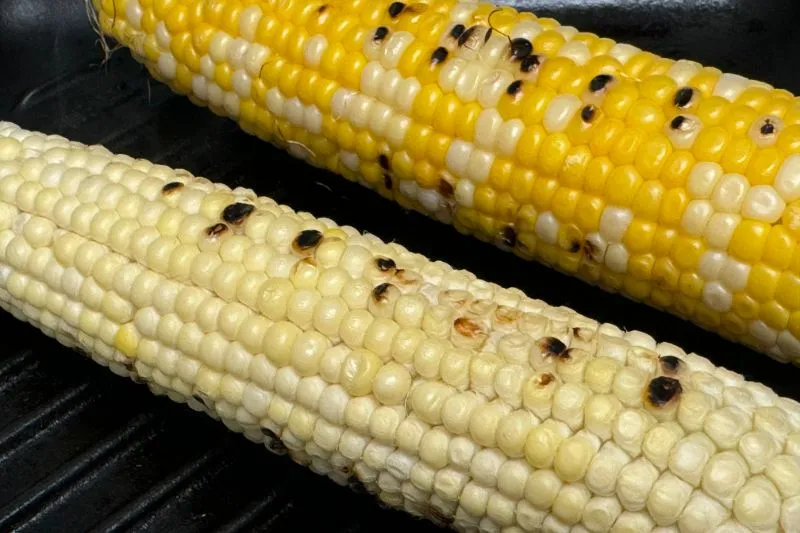 ears of corn grilling on grill pan.