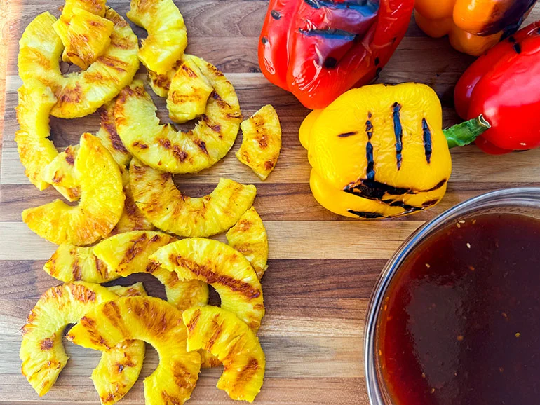 grilled pineapple and peppers and bowl of huli huli sauce.