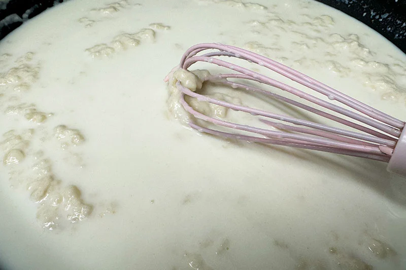 whisking mornay sauce.