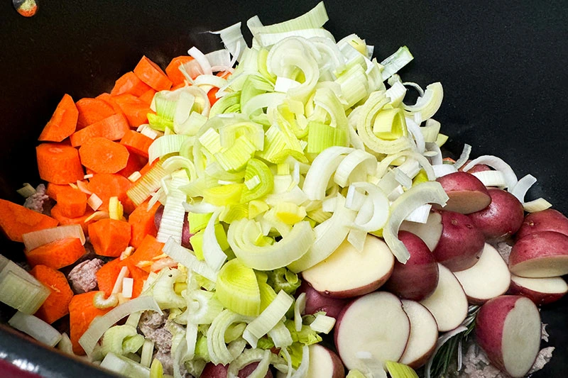 raw veggies added to soup pot.