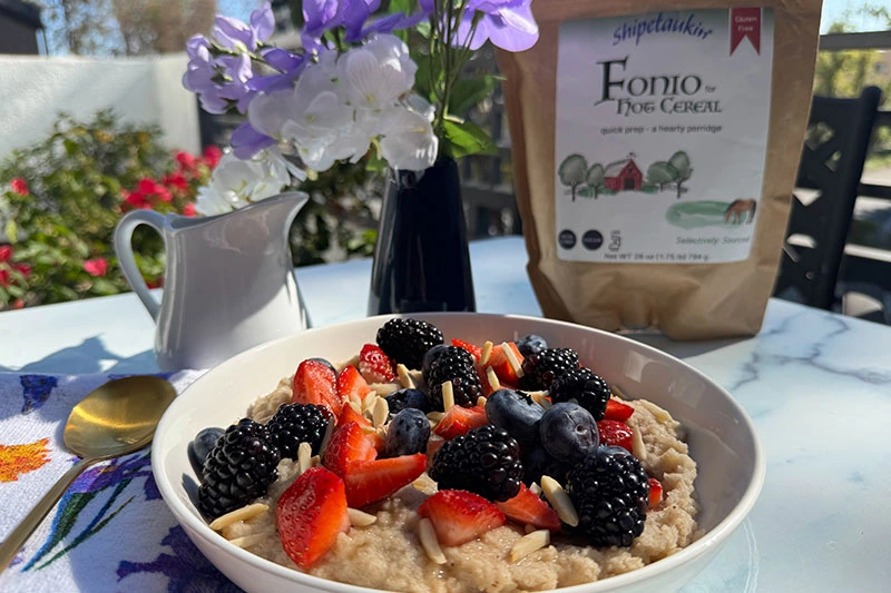 bowl of fonio hot cereal with bag of Shipetauking fonio cereal.