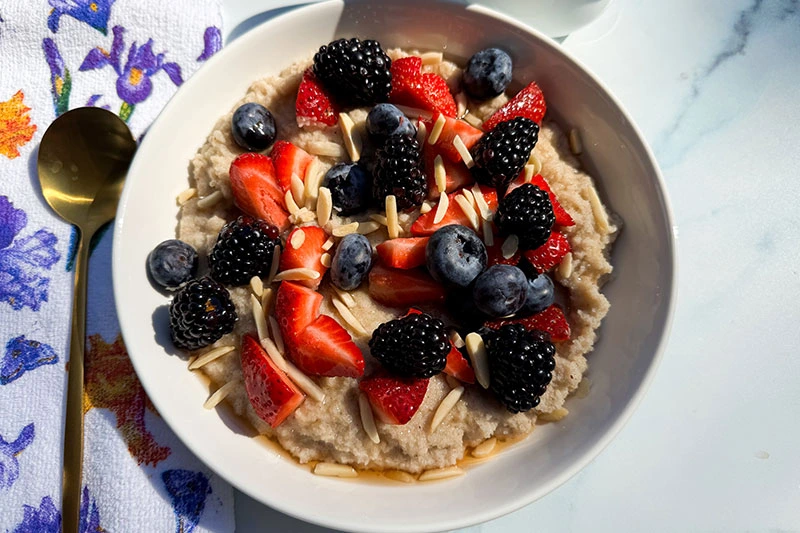 bowl of hot fonio cerea with berries and almonds.