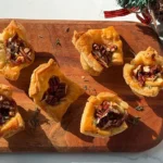 brie fig and pecan puff pastry bites on a serving board.