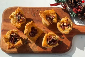 brie fig and pecan puff pastry bites on a serving board.