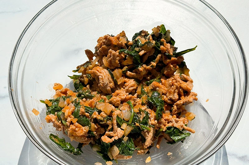 cooked turkey and spinach in a bowl.