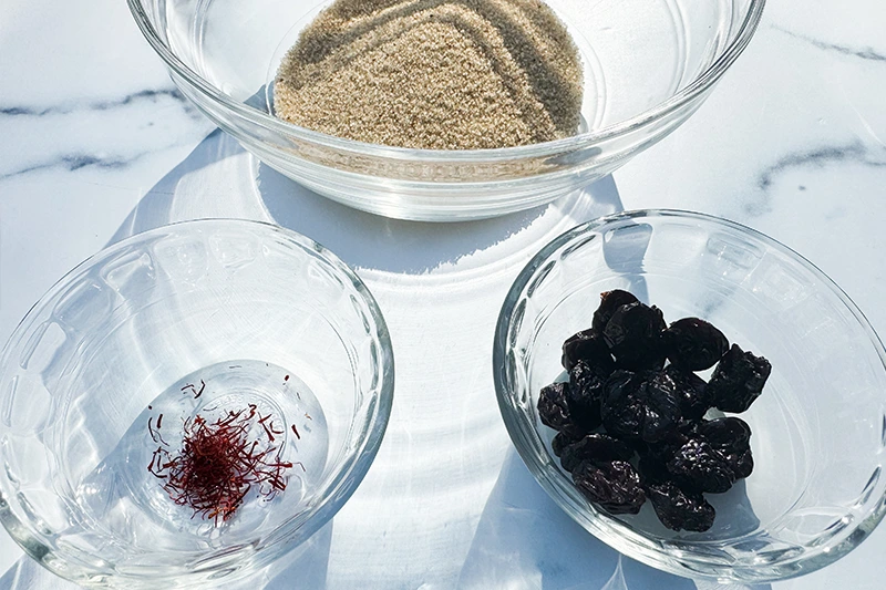 three bowls filled with fonio, saffron and cherries.